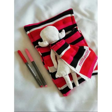 Pecolina à colorier, blanche dans son lit rose et rouge à rayures 